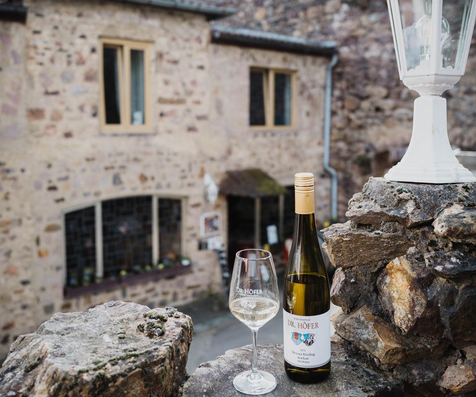 Weinflasche und Weinglas im Weingut Schlossmühle Dr. Höfer in Burg Layen